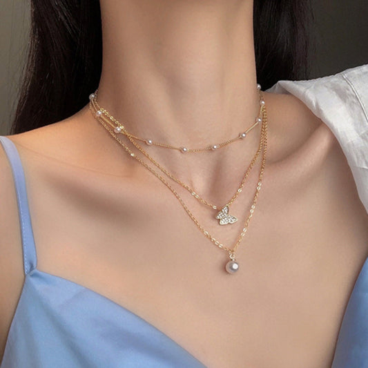 Glitterende Vlinderketting met Parel in Goud